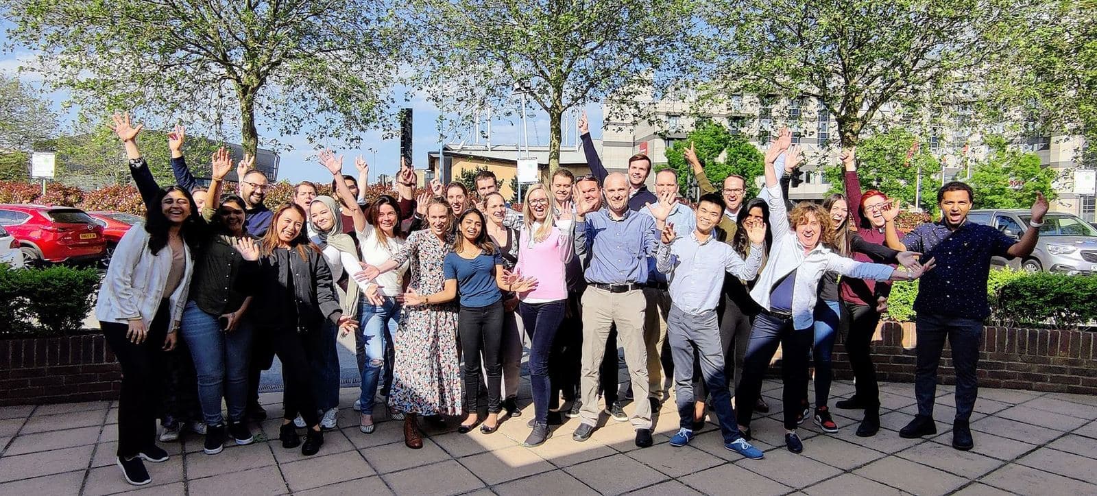 The BAT product development team outdoors with their arms in the air after their two days together