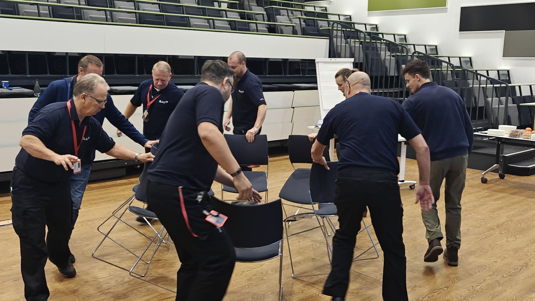 A team taking part in an active exercise with chairs in a training room
