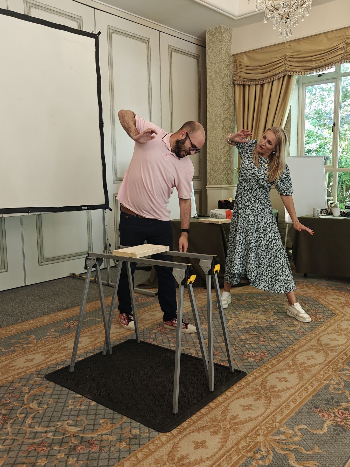 A participant breaking a board while a colleague cheers