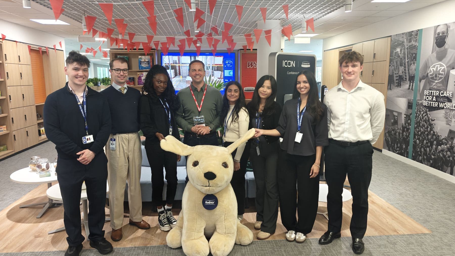 A group of graduates standing together in their company's office