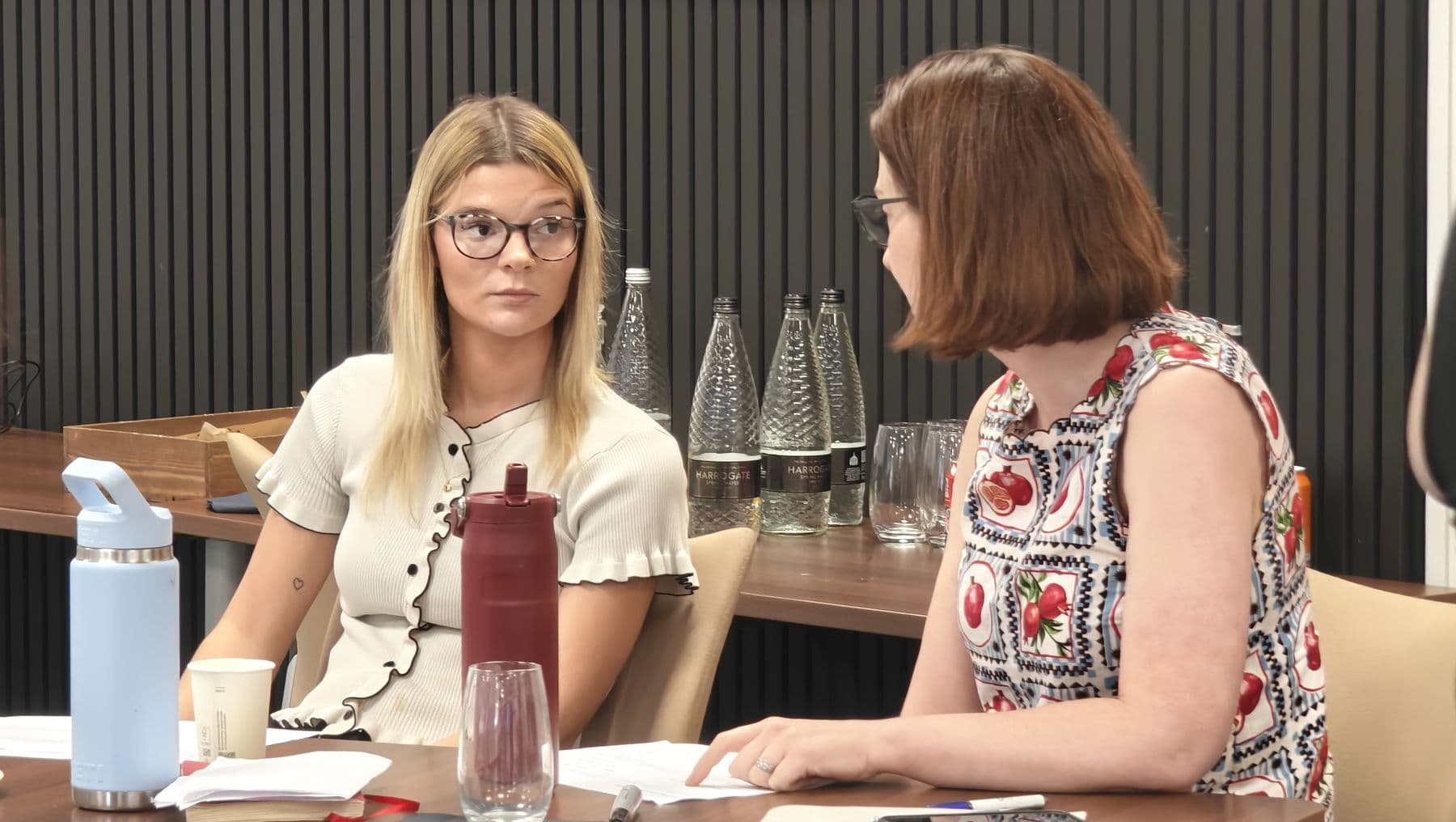 Two participants in conversation across a table during a practice exercise