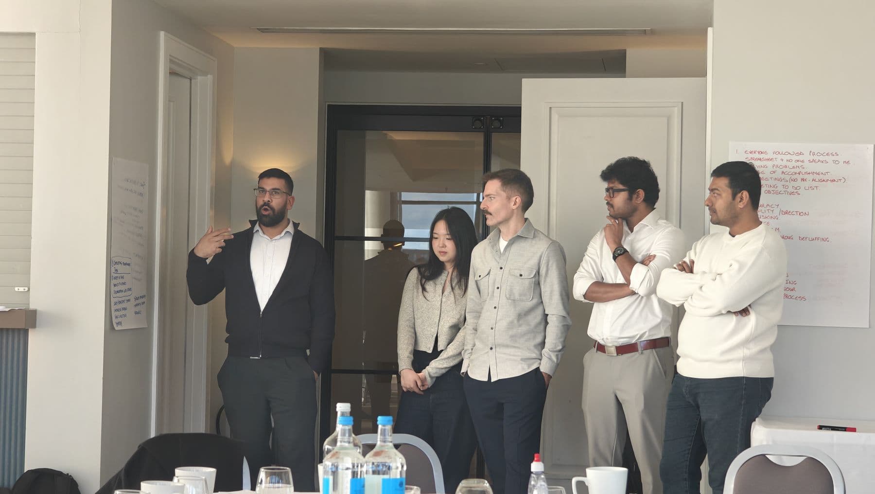 A participant presenting to colleagues standing around him