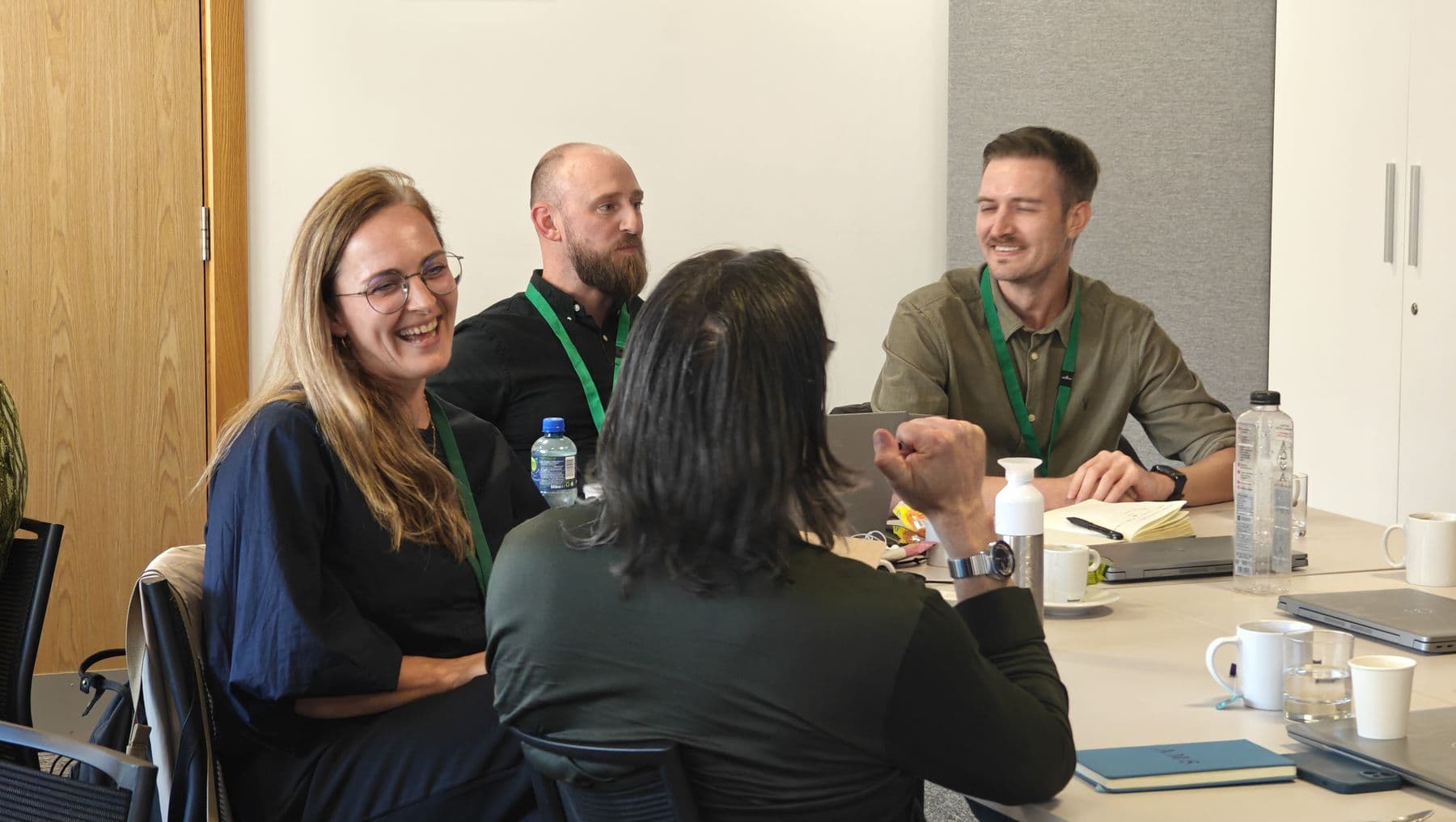 A group smiling and talking together around a meeting table
