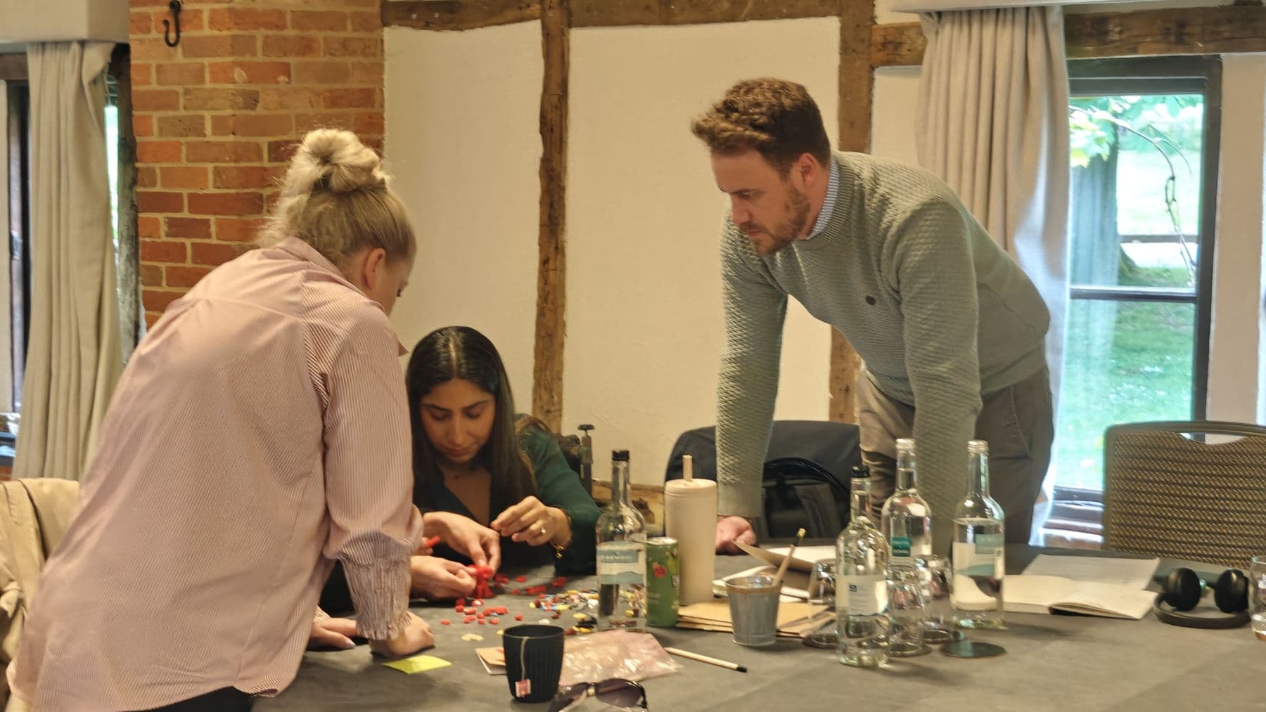 Participants leaning in over a table during a hands-on activity