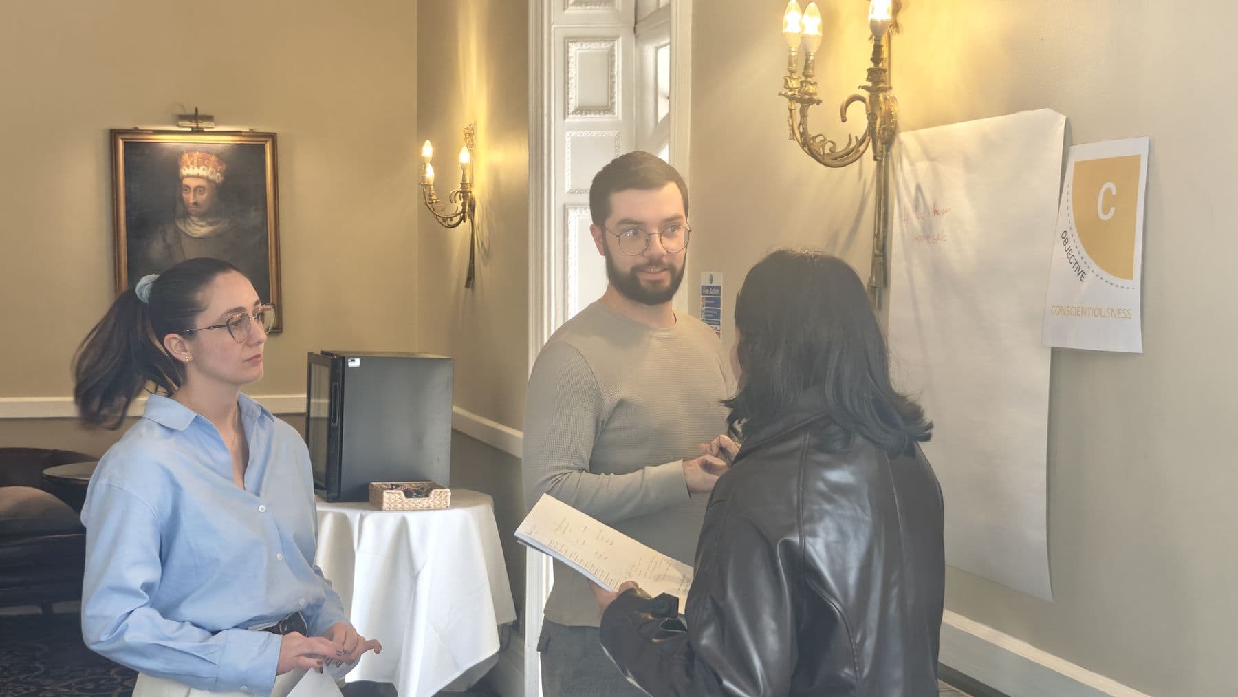Three colleagues talking together during a session in a period room