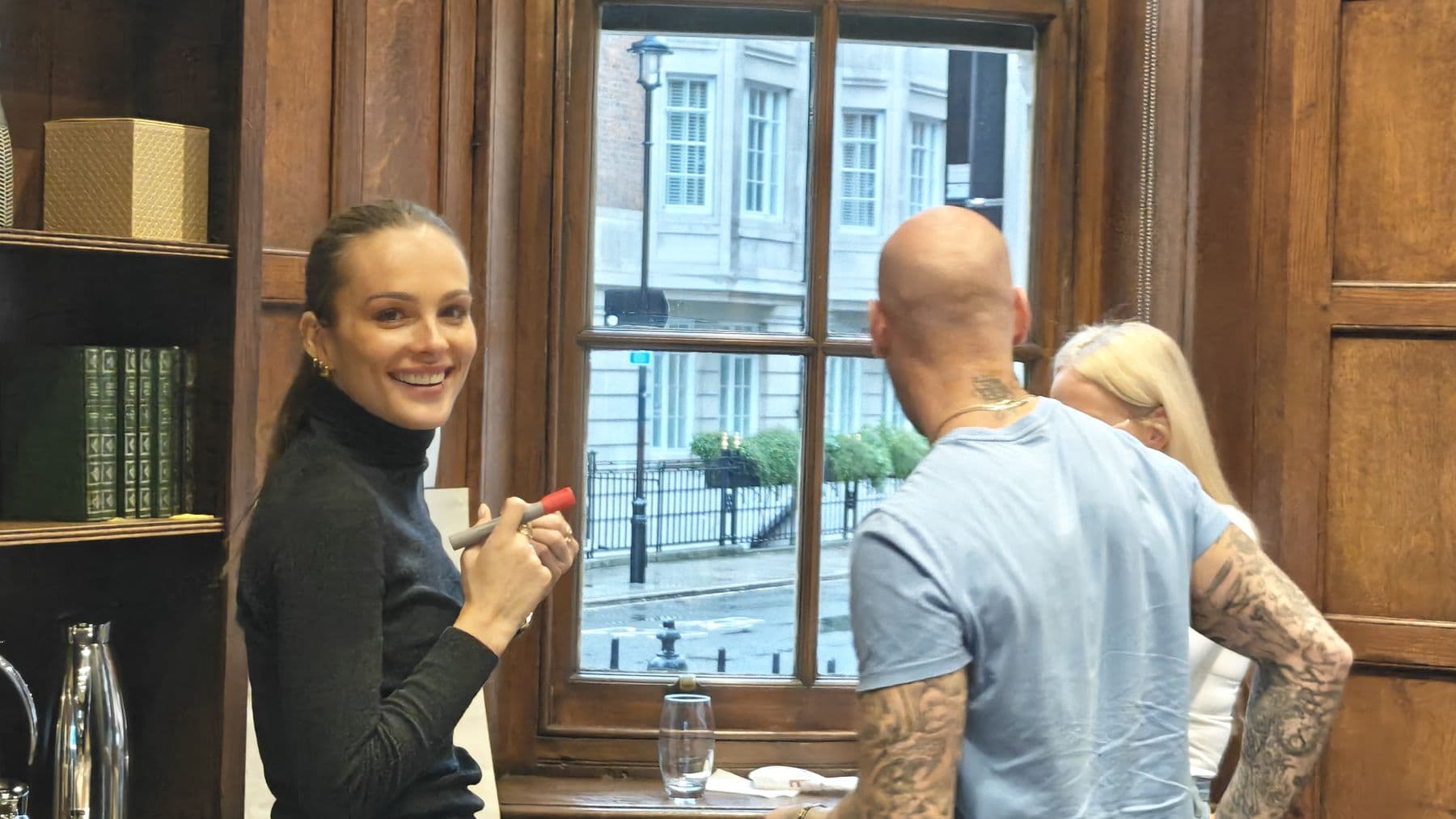 A participant smiling during a conversation by a tall window